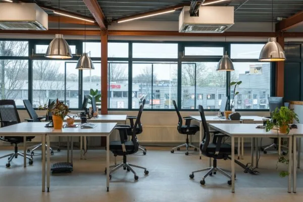 Modern en licht kantoorinterieur aan de Johan van Hasseltweg met bureaus, bureaustoelen, computers en kamerplanten.